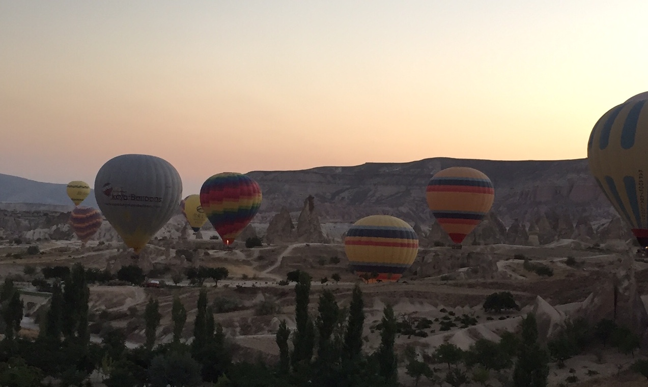 Immagine di sfondo con mongolfiere colorate in volo in un paesaggio stile canyon